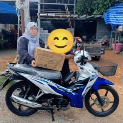 ลูกค้ารับมอบมอเตอร์ไซค์สีน้ำเงินจากร้านธนาสินเงินไว
